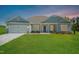 New single-story home with gray siding, two-car garage, and landscaped lawn at 587 Glenkirk Pl, Garner, NC 27529