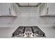 Close-up of gas cooktop with white subway tile backsplash at 601 Emerald Bay Cir, Raleigh, NC 27610