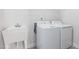 Bright laundry room, featuring a washer, dryer, and utility sink at 601 Emerald Bay Cir, Raleigh, NC 27610