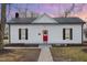 Charming white bungalow with red door, gray walkway, and well-maintained lawn at 334 E Andrews Ave, Henderson, NC 27536
