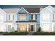 Two-story townhome with gray siding, brick accents, and a charming front porch at 391 Fosterton Cottage Way, Raleigh, NC 27603