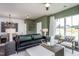 Open concept living room with green accent wall, comfortable seating, and large windows at 391 Fosterton Cottage Way, Raleigh, NC 27603