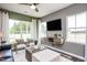 Cozy living room with large windows, neutral colors, and a stylish media console at 391 Fosterton Cottage Way, Raleigh, NC 27603
