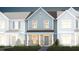 Two-story townhome with gray siding, brick accents, and landscaping at 393 Fosterton Cottage Way, Raleigh, NC 27603
