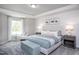 Spacious main bedroom with large window, plush bedding, and stylish nightstands at 393 Fosterton Cottage Way, Raleigh, NC 27603