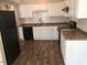 Bright kitchen with white cabinets, black appliances, and wood-look floors at 4600 Millstone Dr # D, Raleigh, NC 27604