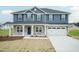 Two-story house with blue siding, stone accents, and a two-car garage at 590 Glenkirk Pl, Garner, NC 27529