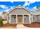 Front view of a gray house with a covered porch, brown door, and white accents at 9437 Bear Run Ln, Middlesex, NC 27557