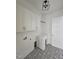 Laundry room with white cabinets and black and white tile floor at 1147 Henderson Tanyard Rd, Pittsboro, NC 27312