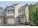 Two-story townhome featuring neutral siding, a white garage door, and landscaping at 121 Cypress Hill Ln, Holly Springs, NC 27540