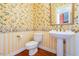 Powder room with pedestal sink and floral wallpaper at 1305 Enderbury Drive Dr, Raleigh, NC 27614