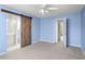 Bedroom with barn door, carpet, and access to bathroom at 2248 Ventana Ln, Raleigh, NC 27604