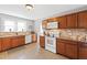 Kitchen with wood cabinets, granite counters, and white appliances at 3200 Bliss Trl, Stem, NC 27581