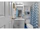 Clean bathroom with white vanity, shower/tub combo, and blue patterned curtain at 816 Westwood Dr, Elon, NC 27244