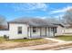 Newly renovated bungalow features a white brick exterior, gray roof, and a covered porch at 115 Kerr Dr, Roxboro, NC 27573