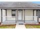 Inviting front porch with gray railings and a white door at 115 Kerr Dr, Roxboro, NC 27573