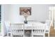 Bright dining room with white table and chairs, featuring a large wall art piece at 1416 Chambers Rd, Rougemont, NC 27572