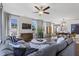 Open living room with gray sectional sofa, large TV, and hardwood floors at 223 Augusta Pond Way # 158, Raleigh, NC 27603