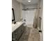 Updated bathroom with gray vanity, shower, and tile floor at 7030 Longstreet Dr # A, Raleigh, NC 27615