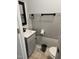 Small bathroom with gray vanity, toilet, and floating shelf at 7030 Longstreet Dr # A, Raleigh, NC 27615