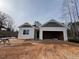 Newly constructed home with gray and white exterior, two-car garage, and partially landscaped yard at 124 Little Creek Dr, Lillington, NC 27546