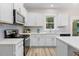 Modern kitchen with white cabinets, stainless steel appliances, and quartz countertops at 1917 A Essex, Durham, NC 27704