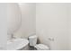 Clean and modern bathroom with a white sink, toilet and oval mirror at 1917 B Essex Rd, Durham, NC 27704