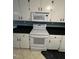 Kitchen features white cabinets, black countertops, and a stove at 209 N Watauga Ave, Dunn, NC 28334