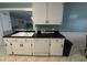 Kitchen with white cabinets, black countertops, and appliances at 209 N Watauga Ave, Dunn, NC 28334