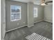 Simple bedroom with gray walls and carpet, featuring two windows at 311 Burnette St, Durham, NC 27707