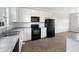 Modern kitchen with white cabinets, black appliances, and gray countertops at 315 Moonlight Dr, Fuquay Varina, NC 27526