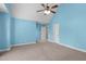 Spacious bedroom with light blue walls, ceiling fan, and carpet at 4616 Transept Ct, Holly Springs, NC 27540