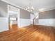 Open dining room with hardwood floors, chandelier, and view of kitchen at 503 Bendemeer Ln, Rolesville, NC 27571