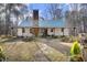 Charming white farmhouse with a green metal roof and stone accents, nestled in the woods at 540 Patterson Dr, Chapel Hill, NC 27516