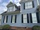 Close-up of blue siding, black shutters and dormers on a two-story house at 7513 Orchard Crest Ct, Apex, NC 27539
