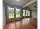 Sunroom with hardwood floors and large windows overlooking the backyard at 7513 Orchard Crest Ct, Apex, NC 27539