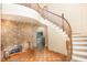 Two-story living room with a stone fireplace and curved staircase at 105 Kingfisher Way, Louisburg, NC 27549