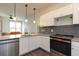 Modern kitchen with white cabinets, granite countertops, and stainless steel appliances at 2202 Gathering Square Ct, Fuquay Varina, NC 27526