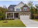 Two-story house with stone and siding, a front porch, and a two-car garage at 3193 Armeria Dr, Apex, NC 27502