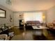 Living room features a brown leather couch and coffee table, hardwood floors, and large windows at 807 W Trinity Ave # 241, Durham, NC 27701