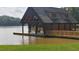 Lakefront boathouse with covered deck and dock at 30 Hidden Lake Dr, Franklinton, NC 27525