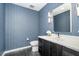 Stylish powder room features modern vanity, blue patterned wallpaper, and dark floor tile at 523 S West St # 402, Raleigh, NC 27601