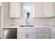 Kitchen sink and white cabinets with marble backsplash at 2407 Hart St # A, Durham, NC 27703