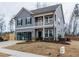 Two story home with gray siding, a two car garage, and a front porch at 817 Heartpine Dr, Mebane, NC 27302