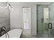 Spa-like bathroom with a soaking tub, glass shower, and gray tile at 8917 Grand Highland Way, Wake Forest, NC 27587