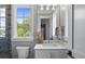Charming bathroom with single vanity, white cabinets, and a window at 8917 Grand Highland Way, Wake Forest, NC 27587