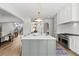 Open kitchen with island, white cabinets, and hardwood floors at 8917 Grand Highland Way, Wake Forest, NC 27587