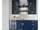 Elegant wet bar with blue cabinetry, quartz countertops, and beverage cooler at 8917 Grand Highland Way, Wake Forest, NC 27587