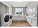 Laundry room with white shaker cabinets, herringbone floors, and built-in sink at 8917 Grand Highland Way, Wake Forest, NC 27587