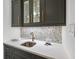 Elegant wet bar featuring dark cabinetry and quartz countertops at 8917 Grand Highland Way, Wake Forest, NC 27587